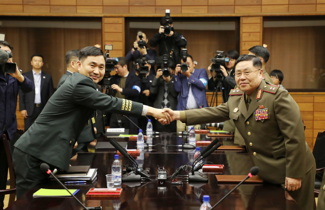 남북 군사당국이 26일 판문점 북측지역 통일각에서 제10차 남북장성급군사회담을 마친 후 남측 수석대표인 김도균 소장(맨 왼쪽)이 종결 발언에 앞서 악수를 나누고 있다. 맨 오른쪽은 북측 수석대표인 안익산 육군 중장이다. 연합뉴스
