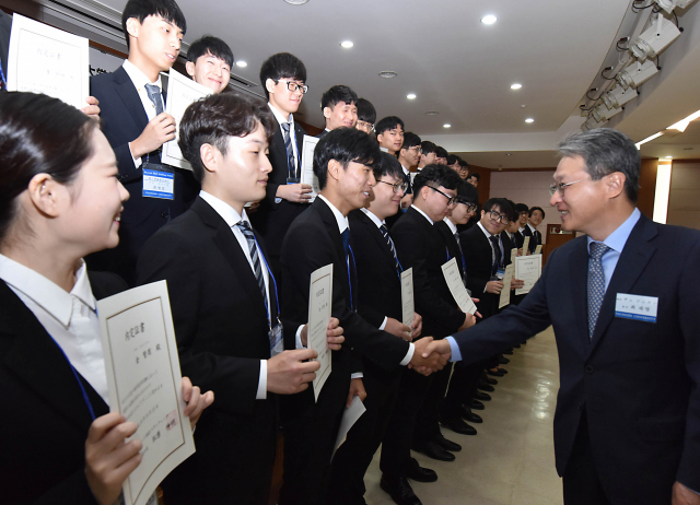 영진전문대학교가 지난 25일까지 사흘간 대학 자체 해외취업박람회을 개최했다. 최재영 총장이 일본 기업으로부터 채용내정서를 받은 학생들을 격려하고 있다. 영진전문대 제공