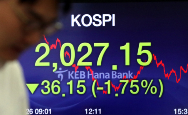 코스피가 36.15포인트 하락하며 2,027.15로 장을 마감해 4일 연속 연중 최저를 기록한 26일 오후 서울 중구 을지로 KEB하나은행 본점 딜링룸에서 한 딜러가 전광판 앞을 지나고 있다. 연합뉴스