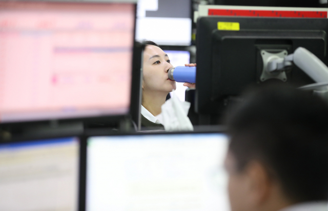 코스피가 1,990선 전후에서 등락을 반복하며 장을 시작한 30일 오전 서울 중구 KEB하나은행 딜링룸에서 한 딜러가 물을 마시고 있다. 연합뉴스