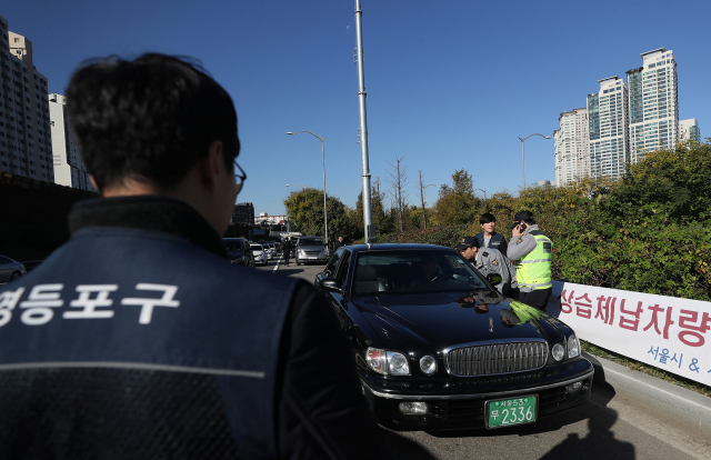 30일 오전 서울 영등포구 올림픽대로 여의교 하단 인근에서 서울시 38세금조사관과 자치구 공무원, 교통경찰관들이 자동차세 2회 이상, 과태료 30만원 이상 체납차량에 대한 합동 단속을 하고 있다. 연합뉴스