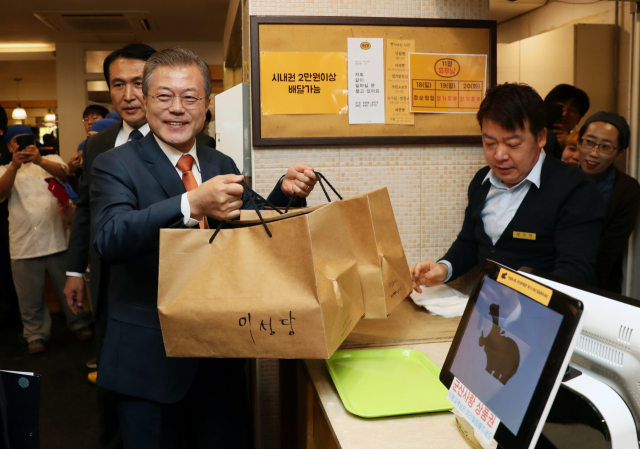 문재인 대통령이 30일 오후 전북 군산의 빵집 이성당을 찾아 계산을 마친 빵을 들고 가게를 나가고 있다. 연합뉴스