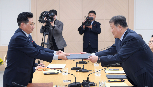 노태강 문화체육관광부 제2차관(오른쪽)이 2일 북측 개성 남북공동연락사무소에서 열린 남북체육분과회담에서 원길우 북한 체육성 부상과 합의문을 교환하고 있다. 연합뉴스