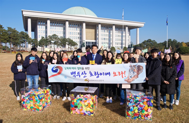 시민단체인 문화재 제자리 찾기 회원들이 5일 오후 국회의사당 앞 잔디광장에서 백두산 호랑이 국내도입을 촉구하는 내용의 퍼포먼스를 펼치고 있다. 사진 제공 송영길 의원실