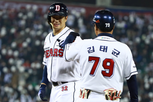 5일 서울 잠실야구장에서 열린 2018 프로야구 한국시리즈 SK 와이번스와 두산 베어스의 2차전 경기. 8회말 무사 주자 1루 때 김재환이 우중간 안타를 친 뒤 1루에 나가 주루 코치와 주먹을 부딪치고 있다. 연합뉴스