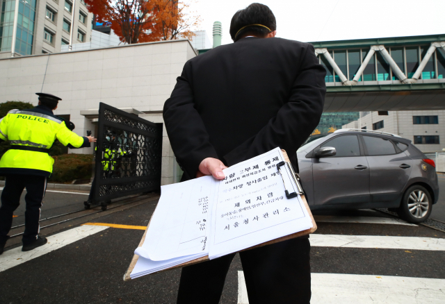 환경부가 수도권 지역에 미세먼지 비상저감조치를 발령한 7일 오전 서울 도렴동 정부서울청사 별관 입구에서 청사 관계자가 차량 2부제 제외 차량 입출입 여부를 확인하고 있다. 비상저감조치에 따라 이날 오전 6시부터 오후 9시까지 행정·공공기관은 차량 2부제가 의무적으로 적용되고 대중교통 이용이 권고된다. 연합뉴스