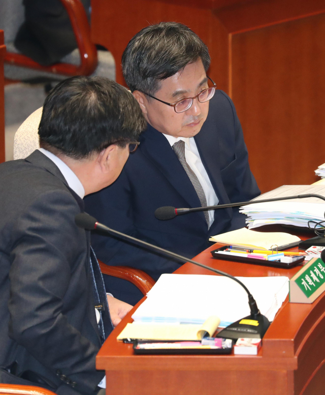 김동연 경제부총리 겸 기획재정부 장관(오른쪽)이 8일 국회에서 열린 예산결산특별위원회 전체회의에서 김용진 기획재정부 차관과 얘기하고 있다. 연합뉴스
