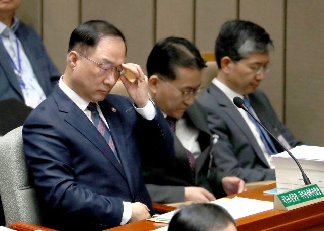홍남기 국무조정실장이 9일 오전 국회에서 열린 예산결산특별위원회 전체회의에 참석해 안경을 고쳐 쓰고 있다. 홍 국무조정실장은 차기 경제부총리 하마평에 올라 있다. 연합뉴스