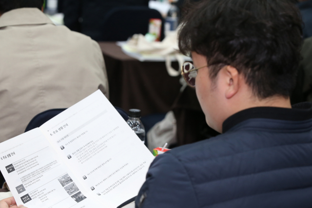9일 오전 전남 화순군 북면 금호화순리조트에서 열린 광주 도시철도 2호선 시민참여단 종합토론회에서 한 시민이 자료집을 살펴보고 있다. 연합뉴스