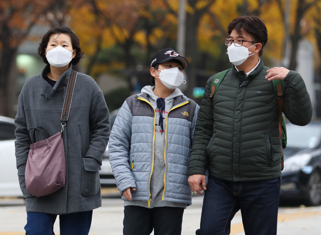 미세먼지 농도가 나쁨을 기록한 11일 오후 서울 세종로사거리에서 마스크를 쓴 가족이 횡단보도를 건너고 있다. 연합뉴스