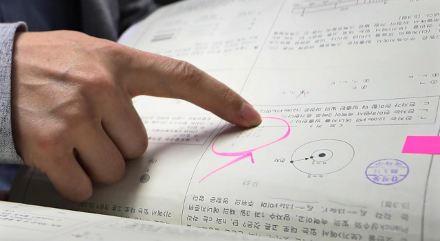 지난해 서울 수서경찰서에서 숙명여고 쌍둥이 자매 문제유출 사건 수사결과 발표에 앞서 경찰이 시험지에 적힌 정답 목록을 공개하고 있다. 연합뉴스