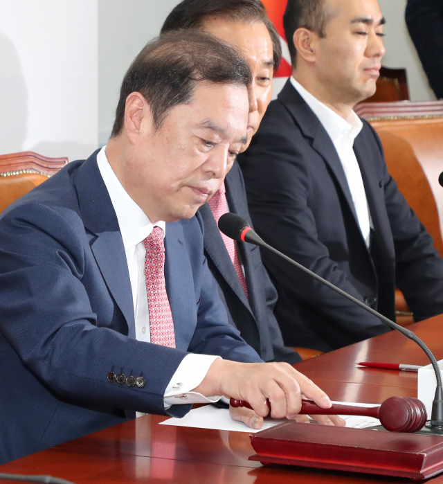자유한국당 김병준 비상대책위원장(왼쪽)이 12일 오전 국회에서 열린 비상대책위원회의에서 의사봉을 두드리고 있다. 연합뉴스