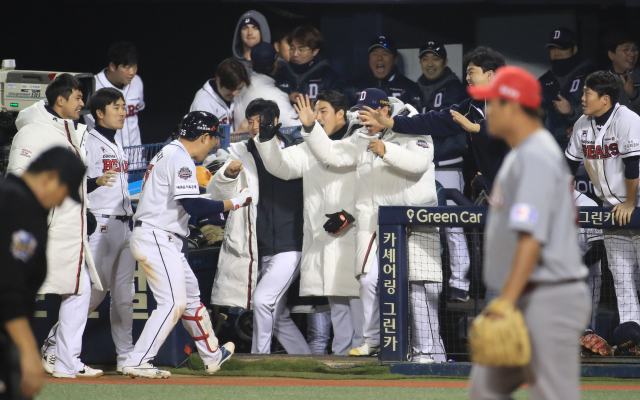 12일 오후 서울 잠실야구장에서 열린 2018 프로야구 한국시리즈 두산 베어스와의 6차전 경기. 8회말 1사 1,3루에서 두산 양의지의 희생플라이가 희생플라이를 친 뒤 동료들과 기쁨을 나누고 있다. 연합뉴스