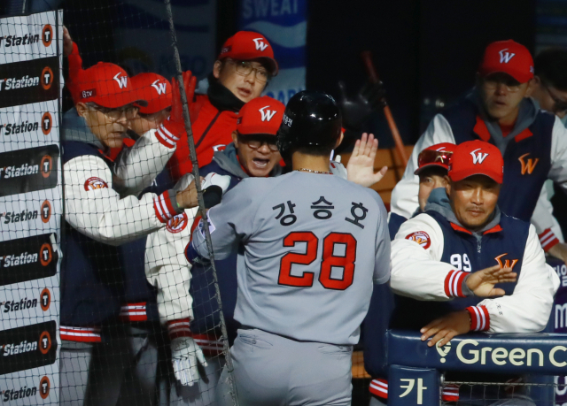 12일 오후 서울 잠실야구장에서 열린 2018 프로야구 한국시리즈 SK 와이번스와 두산 베어스와의 6차전 경기. 4회초 2사 주자 1루 때 SK 강승호가 좌월 2점 홈런을 친 뒤 더그 아웃에 들어와 힐만 감독 등 선수단의 환영을 받고 있다. 연합뉴스