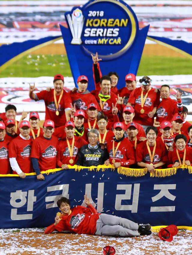12일 오후 서울 잠실야구장에서 열린 2018 프로야구 한국시리즈 두산 베어스와의 6차전 경기에서 우승을 확정한 SK 와이번스 투수 김광현이 우승기 앞에 누워 기념촬영을 하고 있다. 연합뉴스