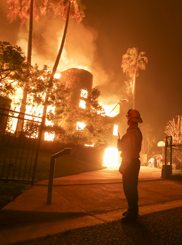 A firefighter keeps watch as the Woolsey Fire burns a home in Malibu, Calif., Friday, Nov. 9, 2018. A Southern California wildfire continues to burn homes as it runs toward the sea. Winds are blamed for pushing the fire through scenic canyon communities and ridgetop homes. (AP Photo/Ringo H.W. Chiu) 美 캘리포니아 산불