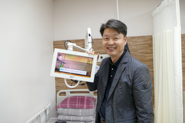 안동 복주요양병원은 호텔형 프리미엄 병동 서비스 적용 첨단 IT기술을 도입했다. 이윤환 이사장이 방송을 시청하거나 가족과 영상통화를 하는 데 사용되는 환자 침대에 설치된 태블릿PC를 설명하고 있다. 김영진 기자