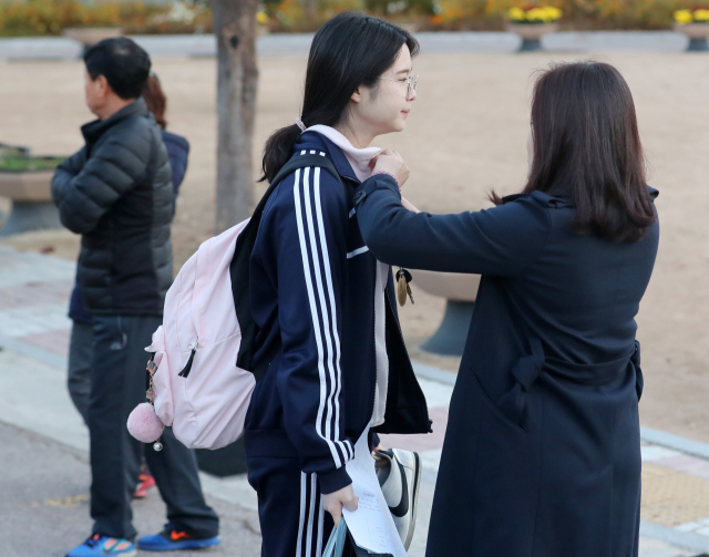 2019년도 대학수학능력시험일인 15일 오전 부산 동래구 중앙여고에서 한 학부보가 수험생 딸의 옷 매무새를 만져주고 있다. 연합뉴스