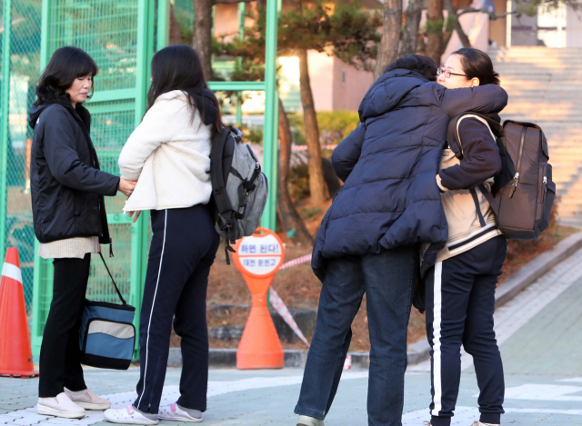 대학수학능력시험날인 15일 대전 둔원고 고사장을 함께 찾은 한 어머니가 시험을 보러 들어가는 자녀를 안아주고 있다. 연합뉴스 #2019 수능 #수능 수험생 #수능 응원 #수능 끝나는 시간