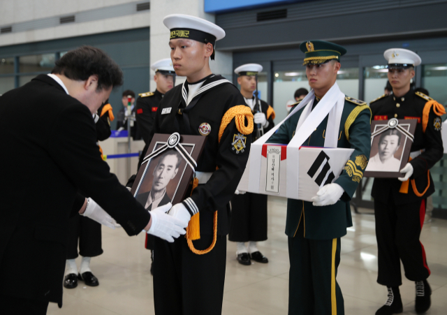 이낙연 국무총리가 15일 오후 인천국제공항 제1터미널 입국장에서 그동안 국외에 안장됐던 민춘기·김산해 애국지사의 유해 봉송 행렬을 묵례로 영접하고 있다. 연합뉴스