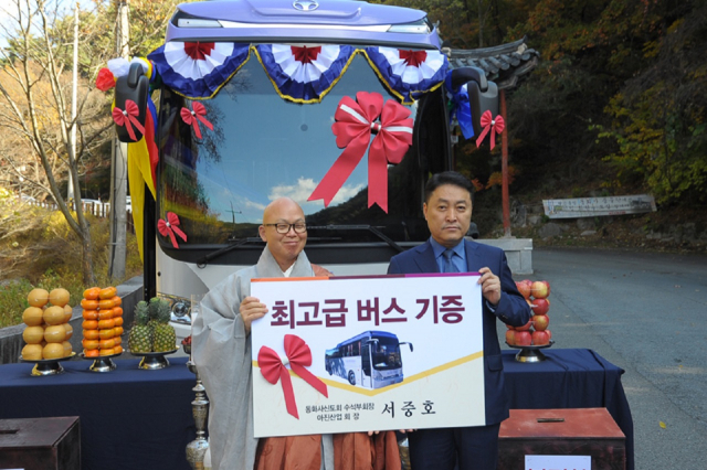 대불총 서중호(사진 오른쪽) 신도회장이 동화사에 45인승 신형 대형버스를 기증하는 행사 모습. 왼쪽은 효광 주지 스님. 동화사 제공