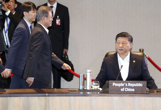 문재인 대통령이 18일 오전 파푸아뉴기니 포트모르즈비 APEC(아시아태평양경제협력체) 하우스에서 열린 정상회의에 참석, 자리에 앉아 있는 시진핑(習近平) 중국 국가주석의 뒤를 지나 자리로 향하고 있다. 연합뉴스