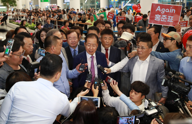 홍준표 전 자유한국당 대표가 두 달간의 미국 생활을 마치고 15일 오후 인천국제공항을 통해 귀국하며 취재진 질문에 답하고 있다. 연합뉴스