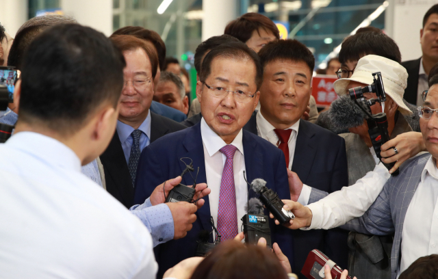 홍준표 전 자유한국당 대표가 두 달간의 미국 생활을 마치고 지난 9월 15일 오후 인천국제공항을 통해 귀국하며 취재진 질문에 답하고 있다. 연합뉴스