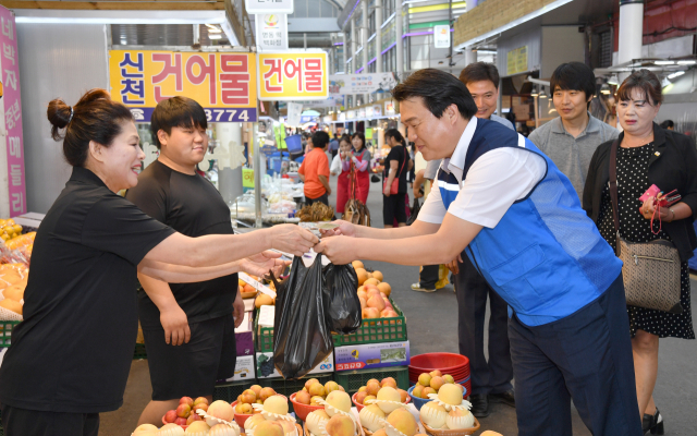 시루로 장을 보고 있는 임병택 시흥시장. 임 시장은 시흥화폐 시루 도입이 결정된 이후 매일 파란 홍보 조끼를 입고 다니며 시루 홍보에 적극 뛰어들었다. 시흥시청 제공