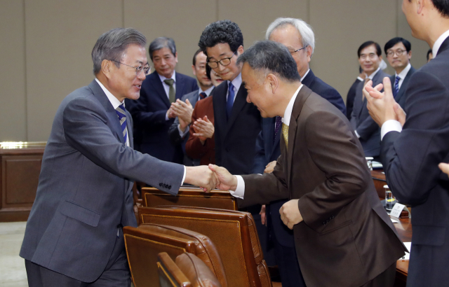 문재인 대통령이 21일 낮 청와대 집현실에서 열린 정책기획위원회를 비롯한 국정과제를 추진하는 직속기구 및 대통령 자문기구 위원들과의 오찬 간담회에 입장하며 송재호 국가균형발전위원장 등과 인사하고 있다. 연합뉴스