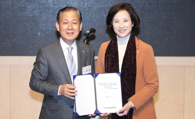 유은혜 사회부총리 겸 교육부 장관이 23일 건국대학교에서 열린 한국사립대학총장협의회(사총협) 정기총회에서 건의문을 받고 있다. 왼쪽은 김인철 사총협 회장. 연합뉴스
