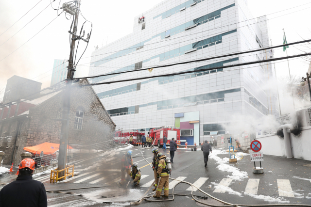 24일 오전 지하 통신구에서 화재가 발생한 서대문구 충정로의 KT 아현빌딩 앞에서 소방대원들이 화재진압 작업을 벌이고 있다. 연합뉴스