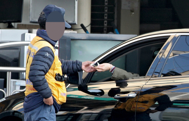 26일 오후 대구 북구의 한 노상 공영주차장에서 관리인이 주차요금을 현금으로 받고 있다. 김영진 기자 kyjmaeil@msnet.co.kr