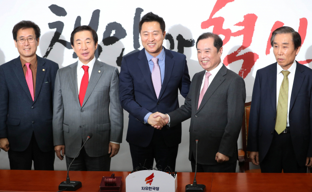 29일 오전 국회에서 열린 오세훈 전 서울시장 자유한국당 입당 환영식에서 오 전 시장이 김병준 비대위원장과 악수하고 있다. 연합뉴스