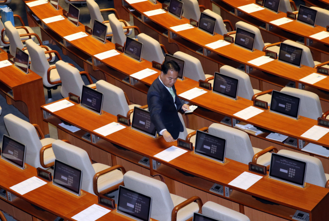음주운전으로 물의를 일으킨 이용주 민주평화당 의원이 29일 국회 본회의장에서 개회에 앞서 의원 각각의 자리에 음주운전에 희생된 윤창호군의 친구들이 제작한 배지가 달린 홍보물을 올려놓고 있다. 연합뉴스