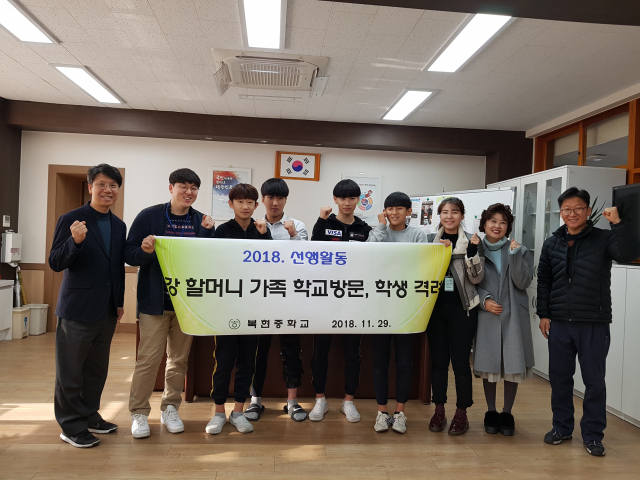 왼쪽부터 이창걸 교장, 할머니 가족, 이지호 군, 김동규 군, 김무겸 군, 배영민 군, 할머니 가족, 최옥화 교감, 유태일 교사