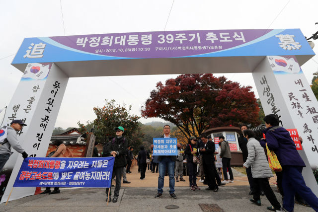 26일 오전 경북 구미 박정희 생가에서 열린 박정희 전 대통령 39주기 추도식에서 참석자들이 장세용 구미시장을 비난하는 내용의 손팻말을 들고 있다. 연합뉴스