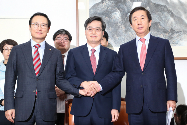 더불어민주당 홍영표 원내대표(왼쪽부터), 김동연 경제부총리 겸 기획재정부 장관, 자유한국당 김성태 원내대표가 6일 오후 국회에서 내년도 예산안 합의 결과를 발표하며 손을 맞잡고 있다. 연합뉴스
