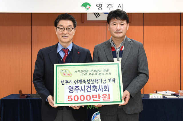 이상원 영주시건축사회 회장이 장욱현 영주시장에게 장학금을 전달하고 있다. 영주시 제공