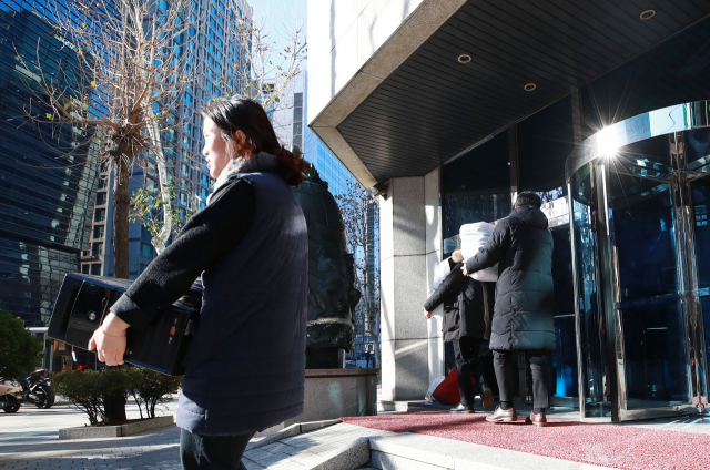 12일 오전 서울 삼성동 대종빌딩 내 입주업체 직원들이 컴퓨터와 가방 등 짐을 챙겨 붕괴 위험에 처한 건물을 나서고 있다. 서울시는 11일 오후 신고를 받고 강남구청과 함께 긴급 점검을 한 뒤 입주자들을 모두 퇴거시켰다고 밝혔다. 연합뉴스