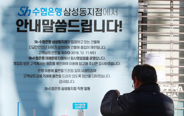 12일 오전 서울 삼성동 대종빌딩 Sh수협은행 삼성동지점에 긴급안전진단 사유에 의한 영업 중단 안내문이 내걸려 있다. 서울시는 11일 오후 신고를 받고 강남구청과 함께 긴급 점검을 한 뒤 입주자들을 모두 퇴거시켰다고 밝혔다. 연합뉴스