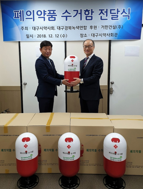 거한건설 이기환(왼쪽) 대표가 12일 폐의약품 수거함을 대구시약사회에 기증하고 있다.