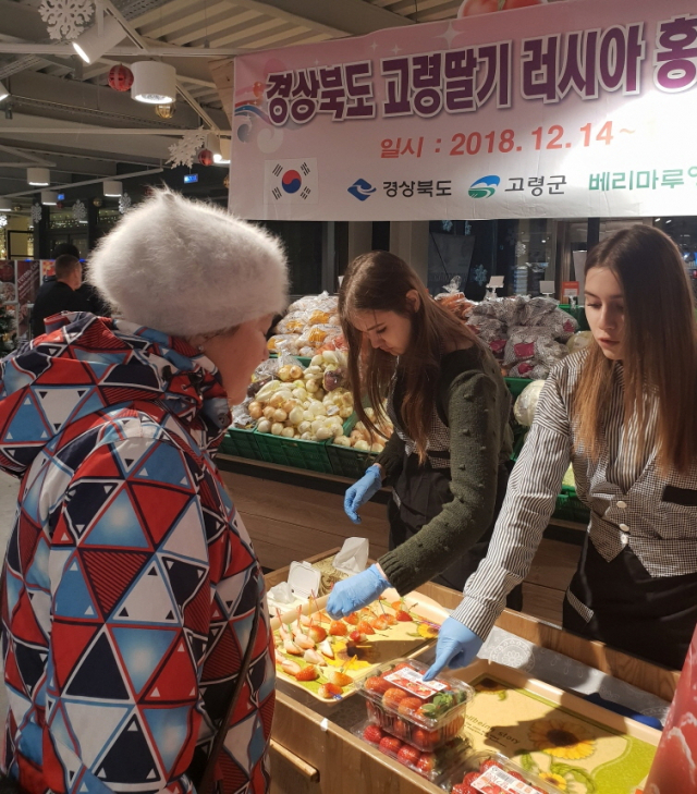 명품 고령딸기 러시아 사할린주 유즈노사할린스크시 시티몰 홍보·판촉행사에서 러시아 도우미가 러시아 소비자에게 고령딸기를 설명하고 있다. 고령군 제공