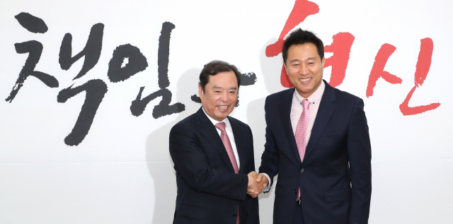 자유한국당 김병준 비상대책위원장(왼쪽)이 3일 오전 국회에서 입당한 오세훈 전 서울시장에게 임명장을 수여한 뒤 손잡고 있다. 연합뉴스