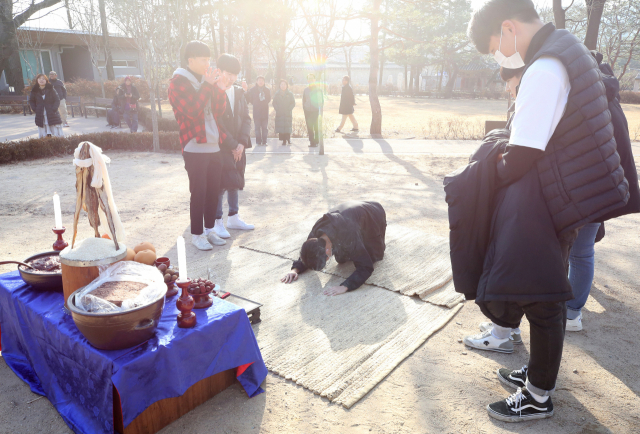 동지 전날인 21일 오전 서울 종로구 국립민속박물관 야외전시장에서 열린 동지 행사장을 방문한 학생들이 고사 체험을 하고 있다. 연합뉴스