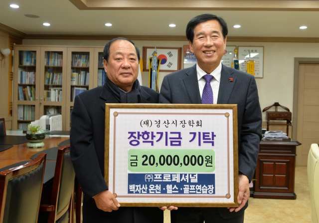 손명길 프로페셔널 회장이 경산시장학회에 약정한 장학금 1억5천만원 중 4차분 2천만원을 최영조 경산시장학회 이사장에게 전달하고 있다. 경산시 제공