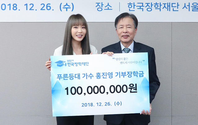 지난 26일 한국장학재단 서울사무소 대회의실에서 이정우 한국장학재단 이사장(오른쪽)이 가수 홍진영에게 푸른등대 기부장학금을 전달받고 있다. 연합뉴스