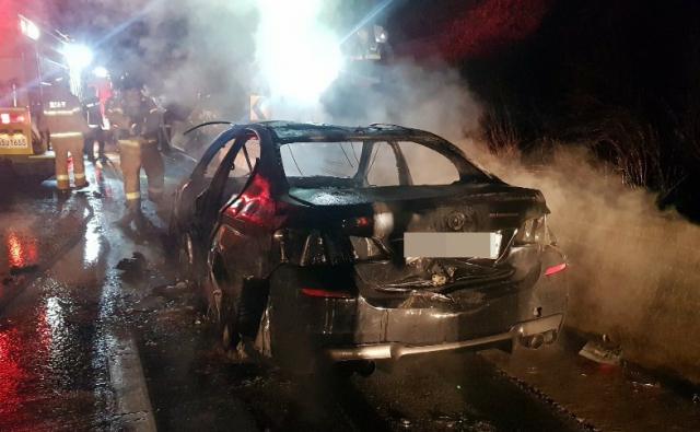 25일 오후 충남 공주시 천안∼논산고속도로 인풍교 인근 갓길에서 119 소방대원이 BMW 520d 승용차 진화 작업을 하고 있다. 연합뉴스