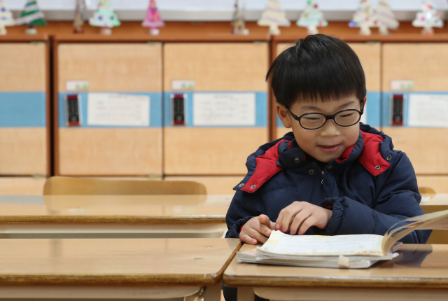 초등학교 신입생 예비소집이 열린 12월 28일 오후 세종시 연세 초등학교에서 한 예비 신입생이 책상에 앉아보고 있다. 연합뉴스