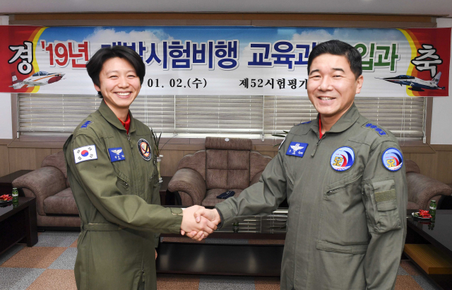 여성 최초 개발시험비행조종사로 선발된 정다정 소령(진)이 2일 공군 사천기지에서 열린 입과식에서 제52시험평가전대장 최정욱 대령과 악수하고 있다. 연합뉴스